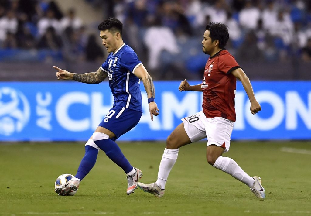 Al Hilal's Ali Al Bulayhi, right, fights for the ball with Urawa