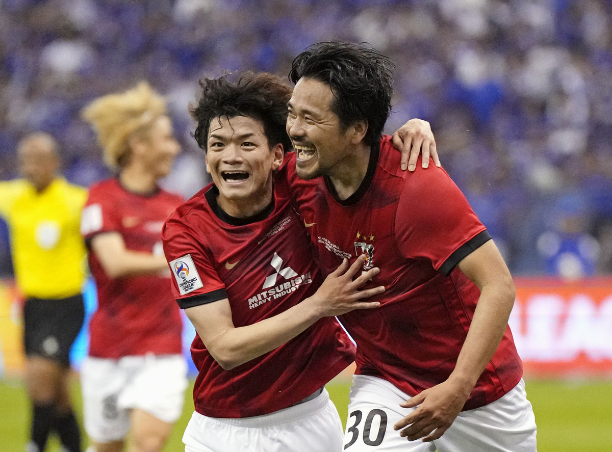 Al Hilal's Ali Al Bulayhi, right, fights for the ball with Urawa