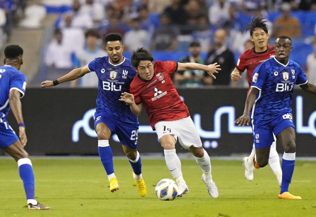 Al Hilal's Ali Al Bulayhi, right, fights for the ball with Urawa